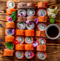 set of sushi roll with salmon, avocado, cream cheese, cucumber, rice, caviar, eel, tuna on wooden table