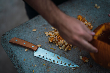 Chico joven con mascarilla por covid 19 preparando calabaza de halloween