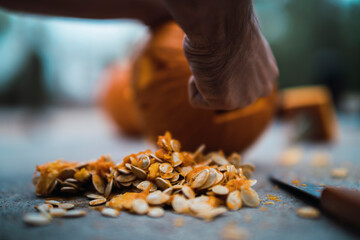 Chico joven con mascarilla por covid 19 preparando calabaza de halloween