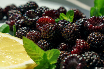ripe juicy blackberries with slice of lemon and green leaves of fresh mint. natural products for a healthy diet