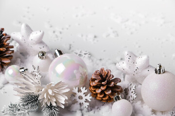 Fototapeta na wymiar Silver and white Christmas balls and ornaments on white snow background
