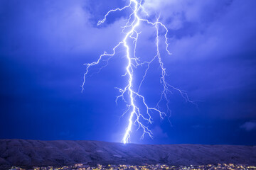 Huge and strong lightning strike at night during a severe thunderstorm - obrazy, fototapety, plakaty
