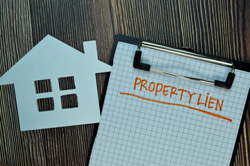 Property Lien write on a paperwork isolated on Wooden Table. Business or Financial Concept