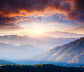 Picturesque sunset in the summer mountains. Evening light illuminates the valley.