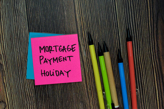 Mortgage Payment Holiday Write On Sticky Note Isolated On Wooden Table.