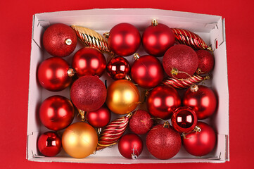 Red Christmas balls in a cardboard box