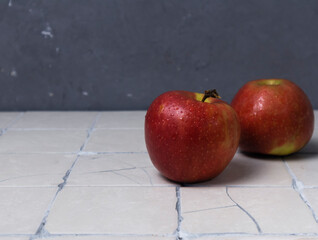 Red apples with drops on a tiled background,creative background, copy space