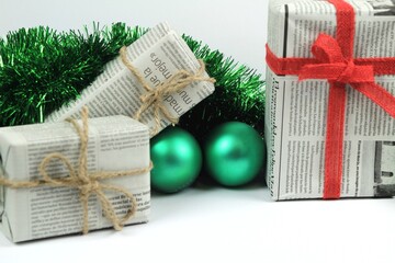Gifts wrapped in old newspaper on white background