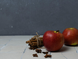 Apples with drops and cinnamon sticks with star anise, autumn layouts, copy space