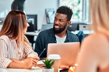 Fototapeta premium Professionals creating new project. Multiethnic business team using tablet at meeting table