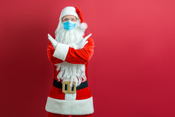 Santa Claus in a medical mask on a red background.