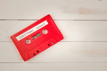 Audio cassette tape with christmas songs on a white wooden background