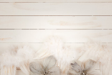 white angel wings on white wooden background