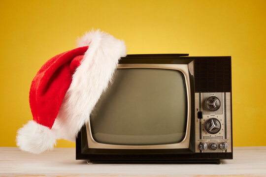 retro television with christmas hat on yellow background
