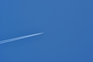 Plane and its contrail in the blue sky