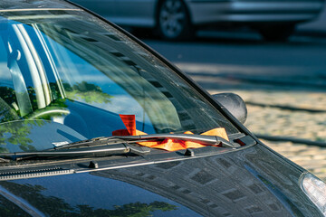 Orange parking ticket on the windshield of a car. Penalty for incorrect parking.