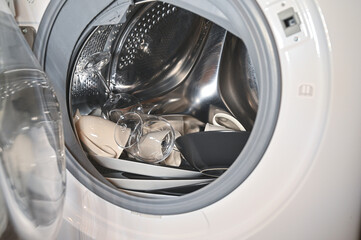 Dirty dishes in a white washing machine. Inside washing machine drum