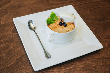 Curd dessert with berries and ice cream with mint leaves. Cottage cheese pie. Cheesecake with berries and sour cream in a white bowl