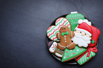 Fototapeta na wymiar Delicious gingerbread Christmas cookies on black table, top view. Space for text