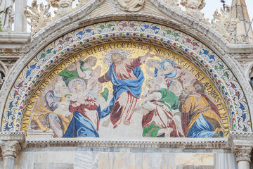 Banner with ancient mosaic at main facade of Basilica San Marco depicting Biblical scene in Venice, Italy, closeup, details.
