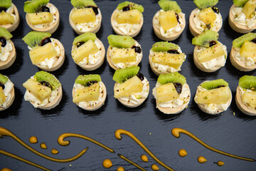 Small tartlets cake with pineapple kiwi and cream