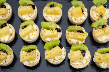 Small tartlets cake with pineapple kiwi and cream