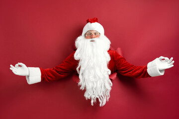 Santa man meditating through hole in paper. Discount. Christmas sales. Christmas decorations. Space for text. Holiday poster design, banner.