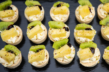 Small tartlets cake with pineapple kiwi and cream
