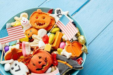 Halloween Jack o Lantern candy bowl with candy and halloween cookies Trick or Treat on patriotic american background, usa flag