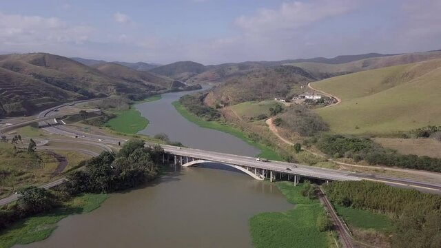 Aerial drone view of car traffic on bridge at Rodovia Presidente Dutra, BR 116, in Vale do Paraiba river on sunny summer day. Concept of transportation, logistics, co2, pollution, emissions, travel.