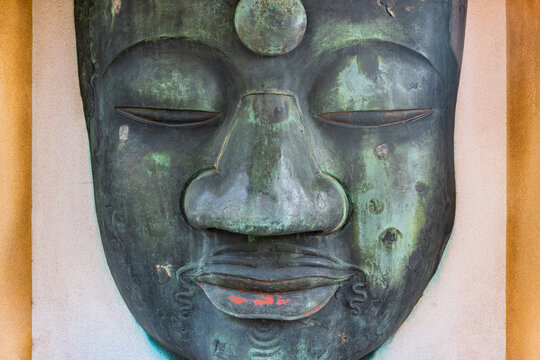 Close-up on the remains of the Ueno Daibutsu in the Kaneiji temple depicting the face of the japanese buddha Shaka Nyorai restored after the Great Kantō earthquake.