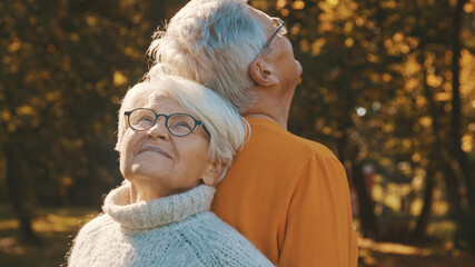 Love and affection at old age. Retired couple enjoying autumn day in forest. High quality photo