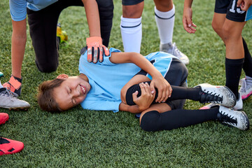 little caucasian boy fell to his knee, ache in joints during football game outdoors, injury during...