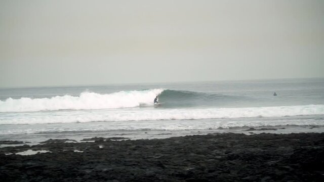 Surfer riding and turning with spray on powerful ocean wave.Surfing ocean lifestyle.