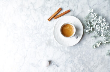 Obraz na płótnie Canvas Cup of espresso, cinnamon sticks and Christmas decoration on marble background. Flat lay