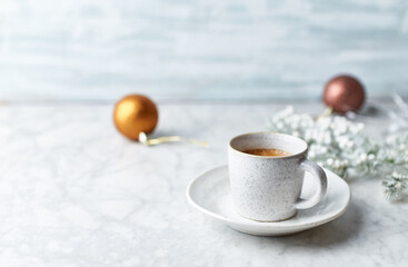 Obraz na płótnie Canvas Cup of coffee and Christmas decorations on bright stone background. Copy space