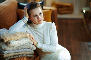 Obraz premium female with sweaters in modern living room in sunny winter day