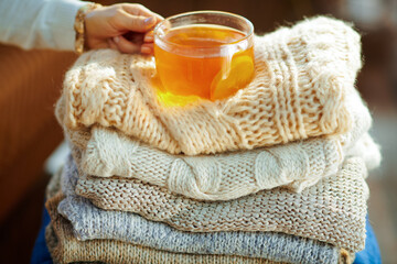 Closeup on stylish woman with sweaters and tea