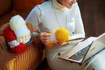 Closeup on smiling modern female with yarn learn how to knit