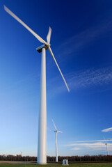 Large spinning Wind turbines against a blue sky