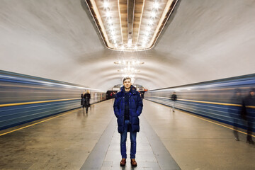 A man stands at the metro station. Motion blur subway and people waiting at subway station.