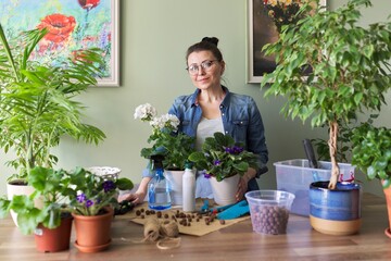 Woman caring for potted plants, replanting, fertilizing.