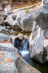 Stream and waterfall flowing through sculptured rocks in the woods