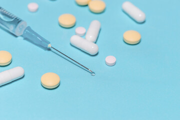 close up. syringe and tablets on a blue background.