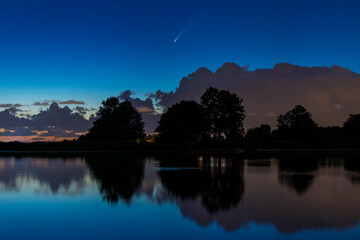 Meteor, shooting star or falling star seen in a night sky with clouds. Comet NEOWISE, C/2020 F3