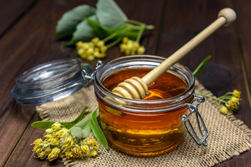 Linden honey in glass jar and linden flowers