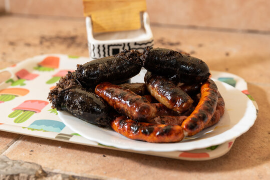 Longanizas y morcillas sobre un plato blanco, barbacoa