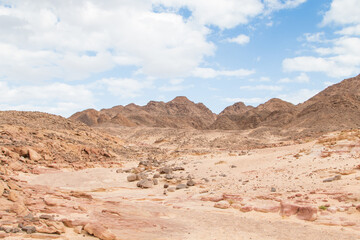 Desert, red mountains, rocks and cloudy sky. Egypt, color canyon.