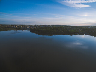 Sunset over a river with forest and a city on horizon. Almost dusk.