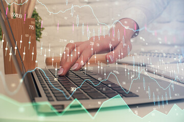 Multi exposure of woman hands typing on computer and forex chart hologram drawing. Stock market analysis concept.